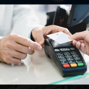 A credit card is held to a contactless checkout