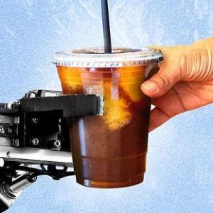 A robot hand gives an iced coffee to a human hand.