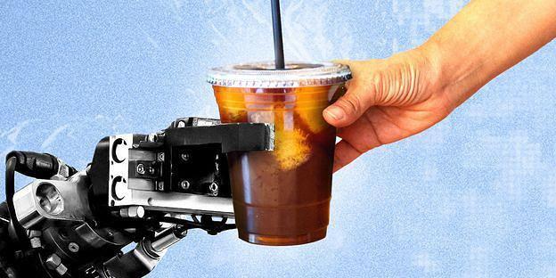 A robot hand gives an iced coffee to a human hand.