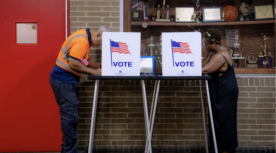 Two people vote at a polling booths